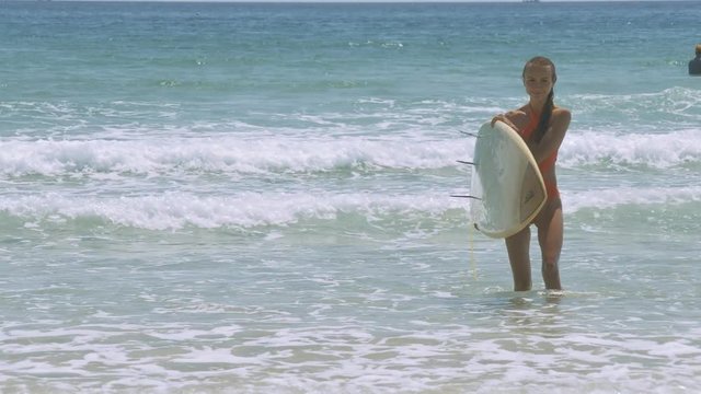 Pretty Girl with Surfing Board Goes out from Waves