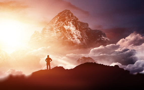 Man standing on a mountain enjoying the sunrise