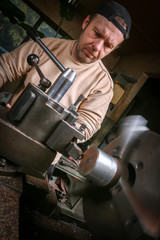 Metal worker working on lathe
