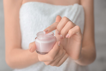 Young woman with jar of hand cream, closeup