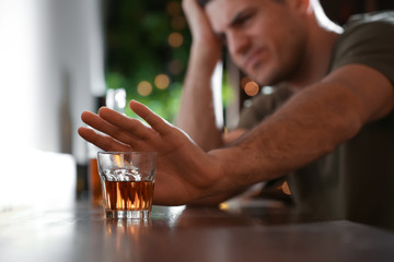 Man refusing to drink alcohol in bar, closeup