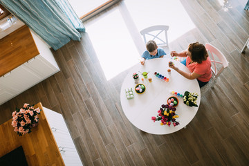 Happy young mother and son are painting Easter eggs