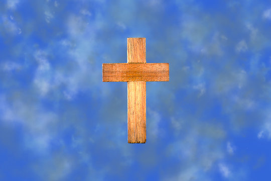 Wooden cross on clouds background