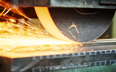 industrial grinding. finishing metal surface on horizontal grinder machine