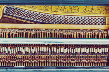 Old piano inside mechanics, colorful hammers and strings background