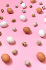 Fototapeta na wymiar Hen white and brown eggs and quail eggs on pink background, copy space. Healthy food concept. Top view, flat lay. Easter eggs. Happy Easter concept