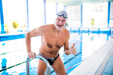 Senior man in an indoor swimming pool.