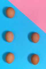 Brown eggs on blue and pink pastel background, copy space. Eggs on paper background with two tone color. Healthy food concept. Easter eggs. Flat lay, top view