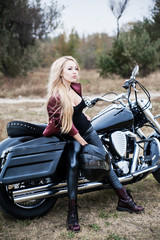 Naklejka na ściany i meble Biker woman outdoor with a motorcycle.