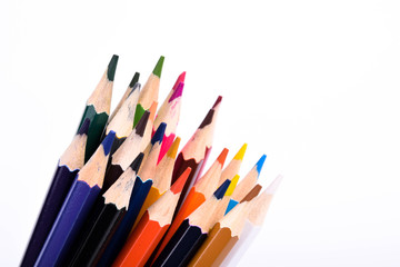 Red pencil standing out from crowd of plenty identical black fellows on white table. Leadership,...
