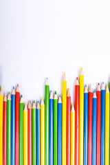 Red pencil standing out from crowd of plenty identical black fellows on white table. Leadership, uniqueness, independence,  initiative, strategy, dissent, think different, business success concept