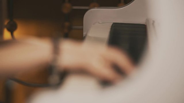 Female hands playing piano. Female hands with bracelet on piano. Woman touches fingers on keys. Close up.