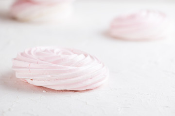 Raspberry meringue on white concrete desk. Space for text.
