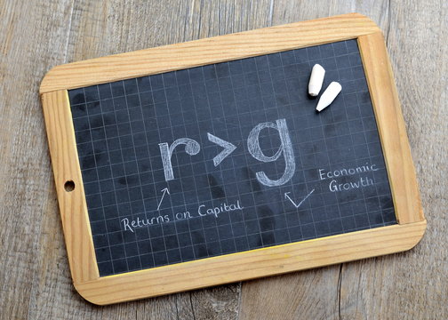 r > g economics equation on chalkboard