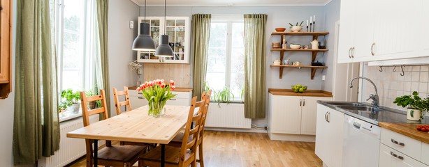 banner of cozy kitchen interior with green curtains and red tulips on the wooden table