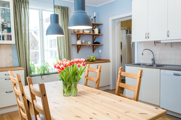 red tulips on the kitchen table in a cozy kitchen 