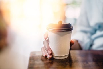 Hot drink in paper cup in hands close up