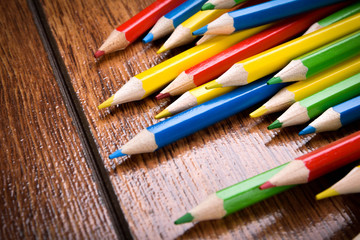 Different colored pencils on the brown wooden table background .Top view .Close up .Color .Pencil.Set