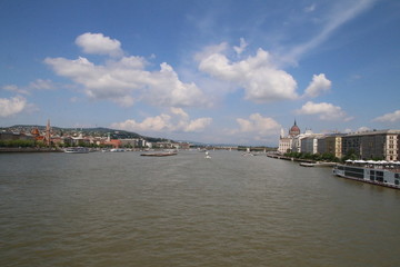 view on the danube river from a Budapest bridge, sunny day and clouds on blue sky