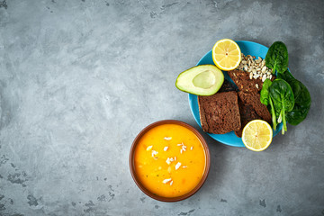 pumpkin cream soup and product set on the blue dish on the concrete backdrop