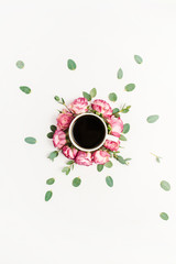 Cup of coffee in frame of pink rose flower buds and eucalyptus branches on white background. Flat lay, top view food concept.