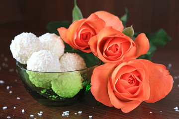 Composition with three roses and candy on dark background