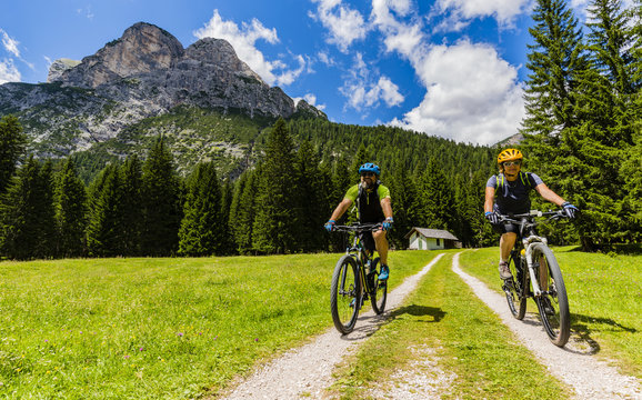 Mountain biking family with bikes on track, Cortina d'Ampezzo, Dolomites, Italy