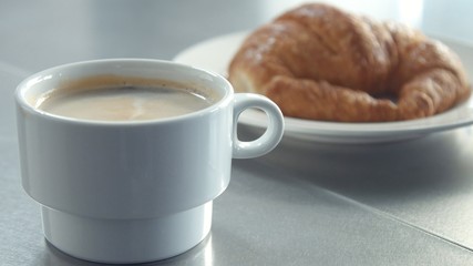 man put cup of coffee on the table closeup video morning light