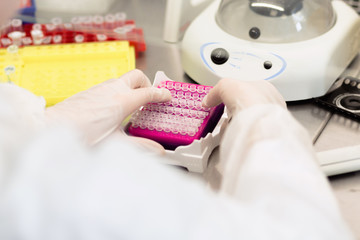 Close-up of female technician with multipipette and in genetic l
