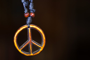 Wooden peace symbol attached to string necklace fairies love not war