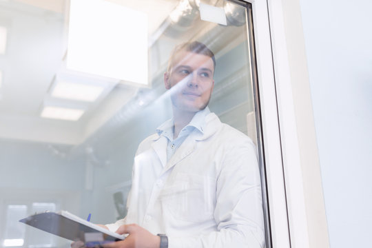 Quality Inspector Wearing White Medical Gown Inspecting A Laboratory. Quality Assurance Concept