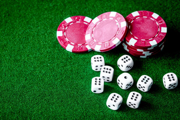 poker chips and dice on green background top view