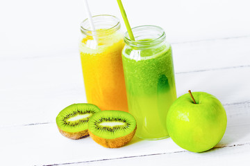 Fresh detox juices in glass bottles on white background
