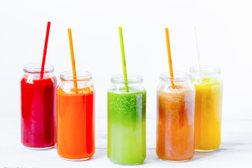 Fresh detox juices in glass bottles on white background