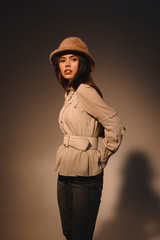 portrait of beautiful woman in fashionable clothing and hat posing on dark background