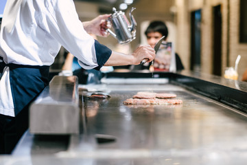 Hand of man take cooking of meat with vegetable grill, Chef cooking wagyu beef in Japanese teppanyaki restaurant