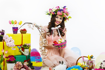 Fototapeta premium Smiling woman holding Easter basket with colored eggs