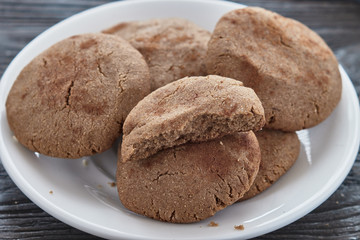 Homemade biscuits of buckwheat flour with honey on a plate on a wooden background.