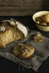 Loaf of rye bread with chicken and quail eggs in wooden box
