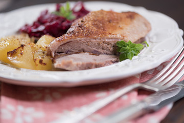 Duck meat with potatoes and braised blue cabbage with raspberries.