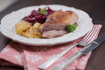 Duck meat with potatoes and braised blue cabbage with raspberries.
