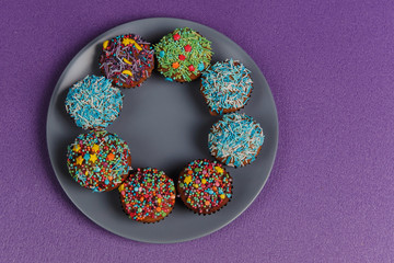 Fresh sweet cupcakes on a purple background.