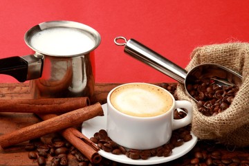 Cup of coffee surrounded by coffee beans