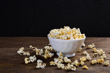 Prepared popcorn in frying pan, corn seeds in bowl and corncobs on kitchen table.Air salty popcorn. Salt popcorn on the wooden background . Chees .Popcorn texture