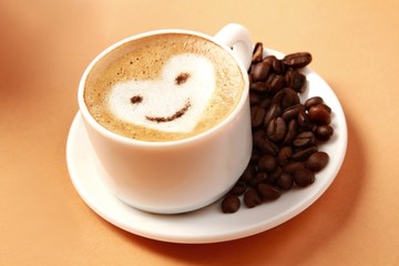 Cup of coffee surrounded by coffee beans
