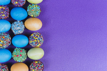 Easter. Easter eggs and Easter cupcakes on a purple background.