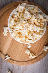 Salt popcorn on the wooden table, selective focus
