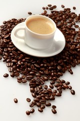 Cup of coffee surrounded by coffee beans