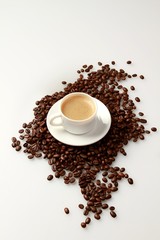 Cup of coffee surrounded by coffee beans