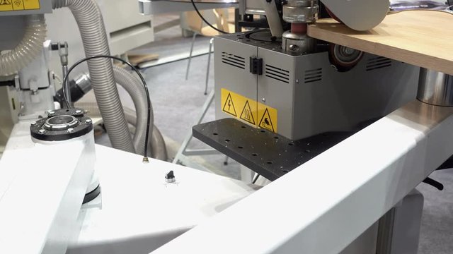 4k view of furniture manufacture. Work of an industrial machine for edge trimming.